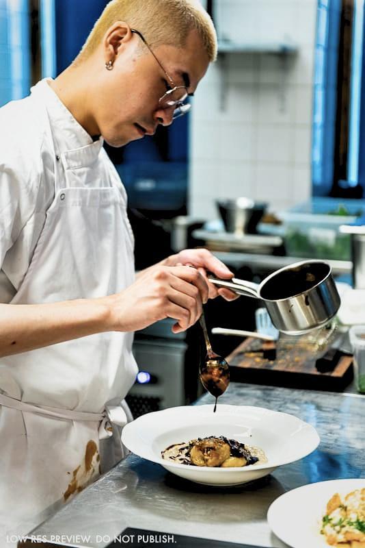 Sơn plating a dish in the kitchen