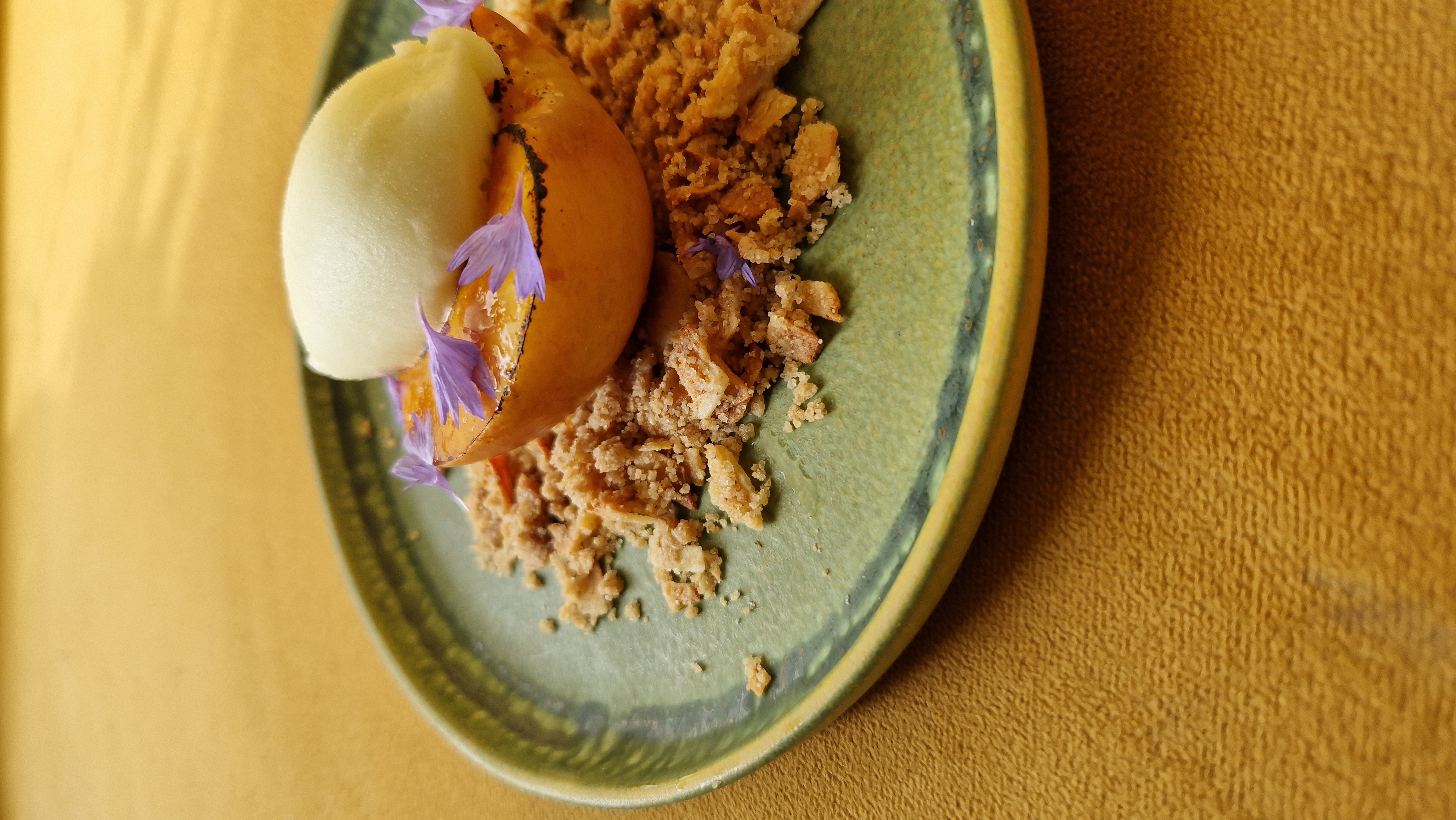 Roasted apricot with sorbet, crumble and edible flowers